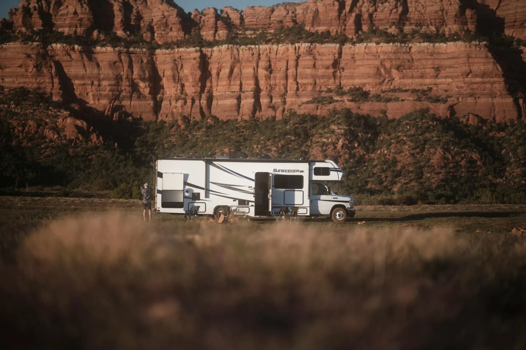 A Sunseeker camper set up in a beautiful desert and rock setting.