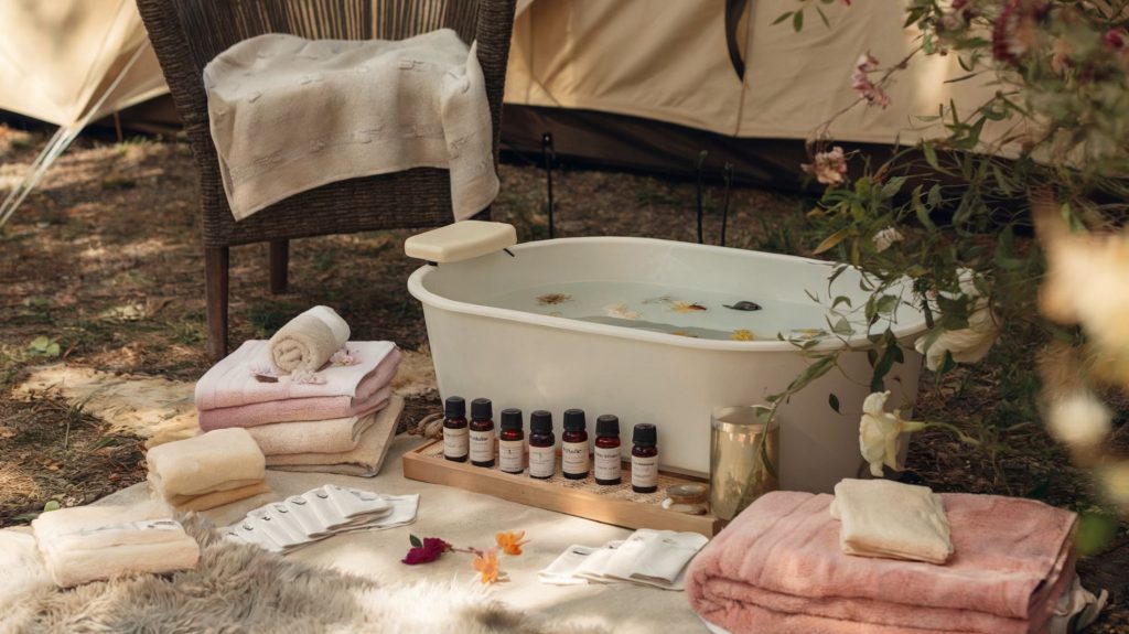 DIY glamping spa retreat featuring a soaking tub, essential oils and flowers for a relaxing moment of glamping.