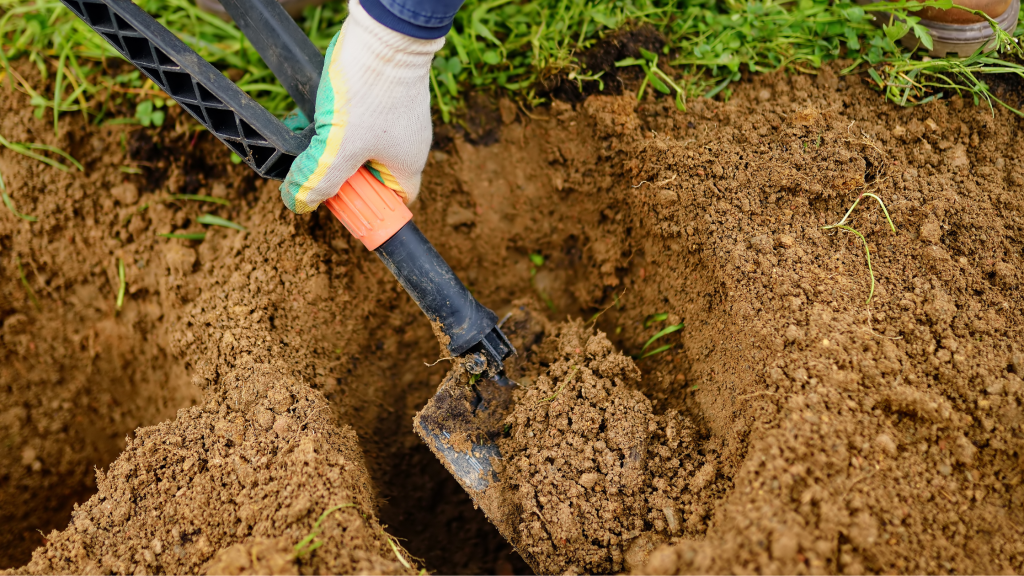 Camper using a camping shovel to dig a hole.