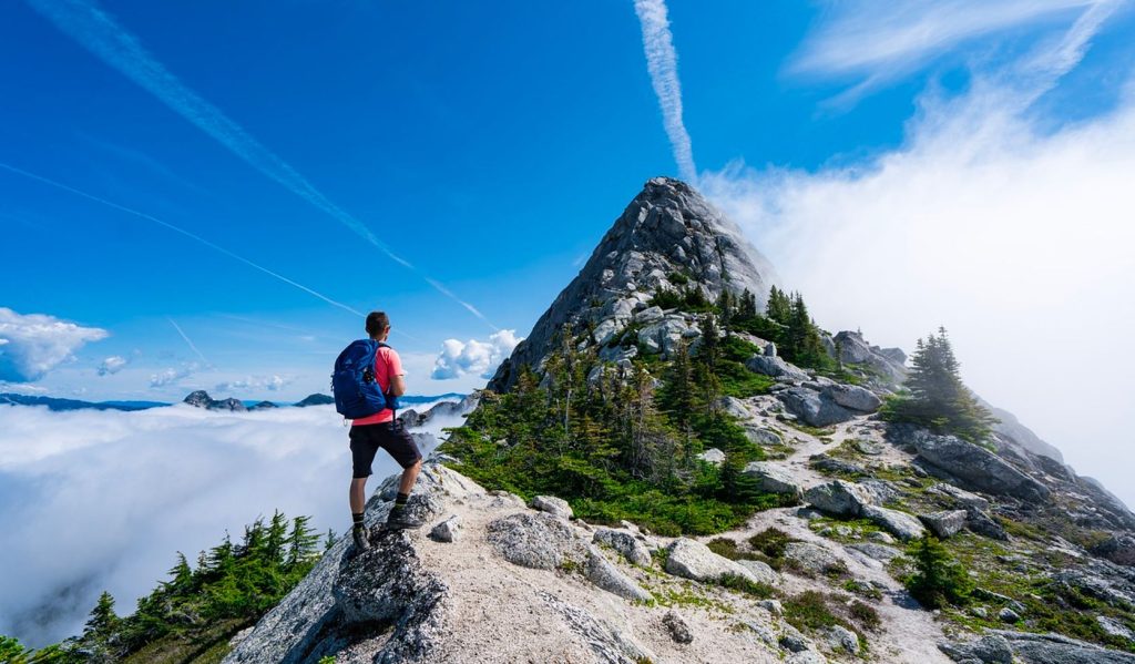 Backpacking man approaching a mountain summit in a dry high-altitude environment, high possibility off dehydration.