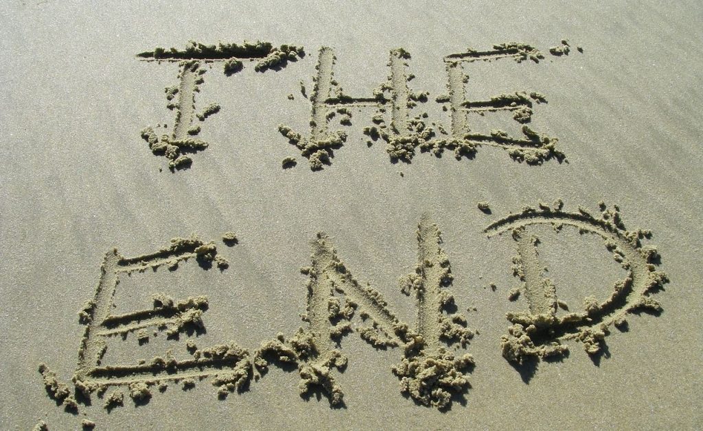 "The End" handwritten in sand at the beach.