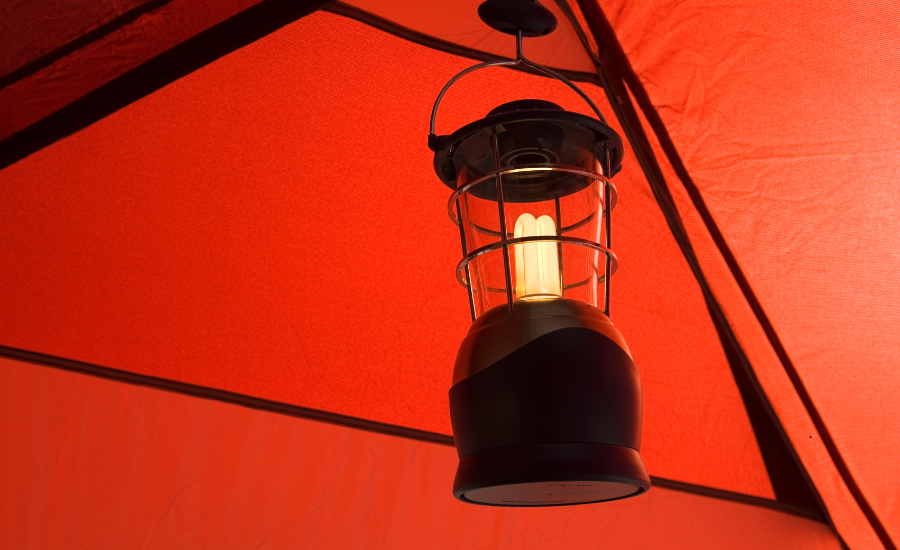 Camping lantern hanging inside a large tent.