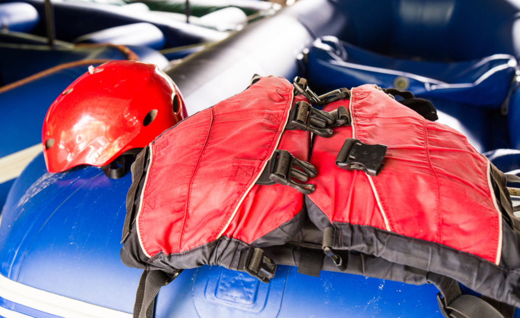 An inflatable kayak showing a life vest and helmet for added safety while kayaking.