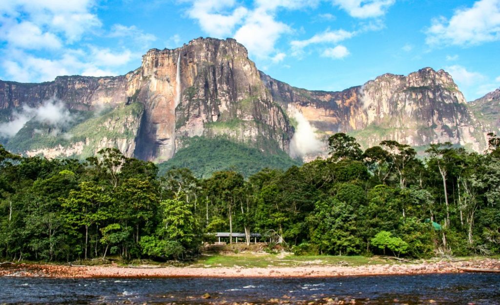Angel Falls as seen from a riverboat near the lush jungle surrounding it. 