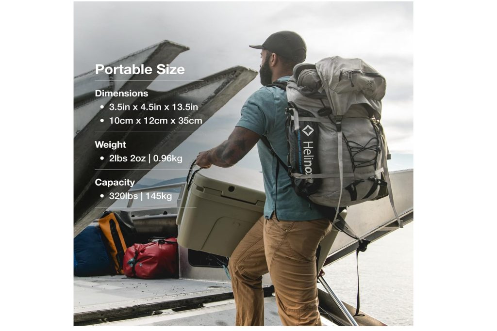 A man is seen loading a cooler onto a truck bed while wearing a backpack that has the Helinox Chair One comfortable attached to the side of the backpack.
